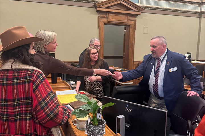 Conservative activist hands checks to lawmakers on Wyoming House floor